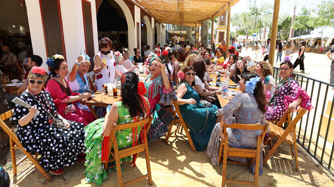 Grupos de mujeres de comida en la terraza de una caseta de la Feria.